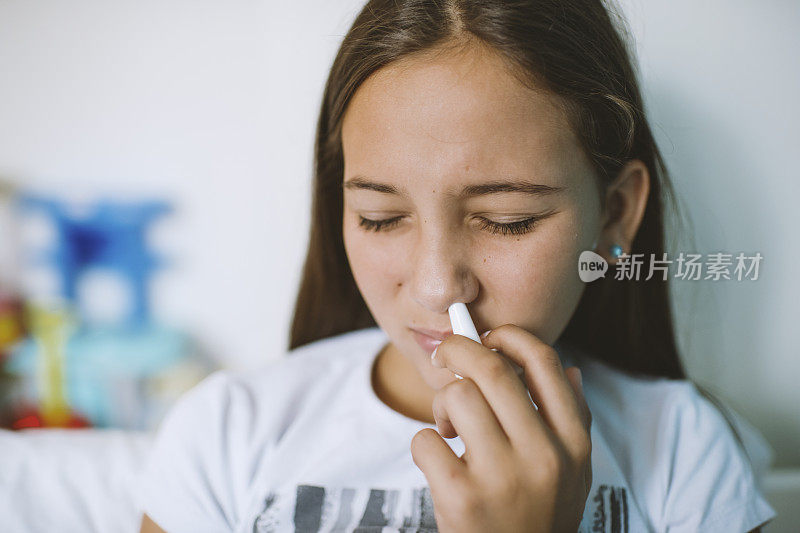 少女因感冒在卧室里使用鼻喷剂