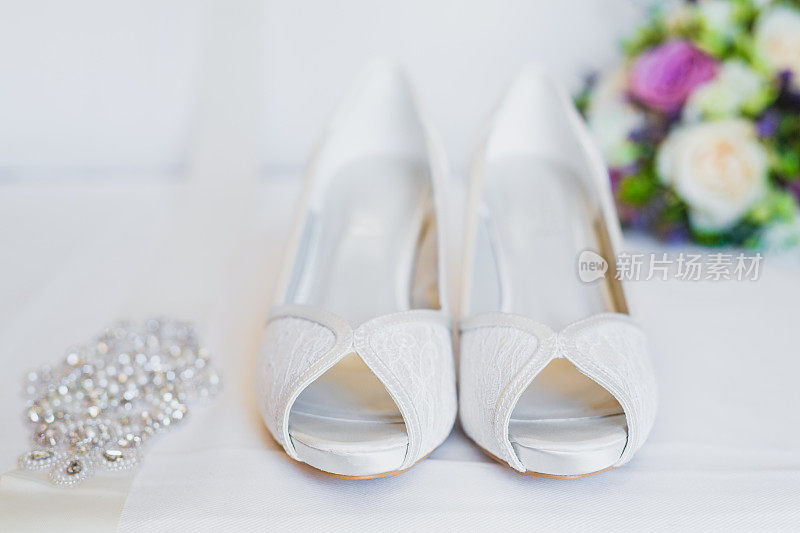 以婚礼花束为背景的新娘鞋