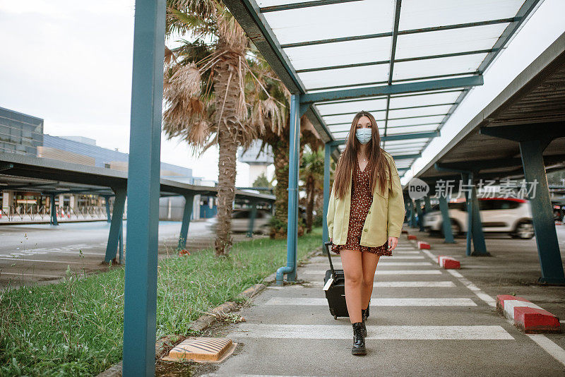 一名年轻女子在机场停车场戴着防护面罩