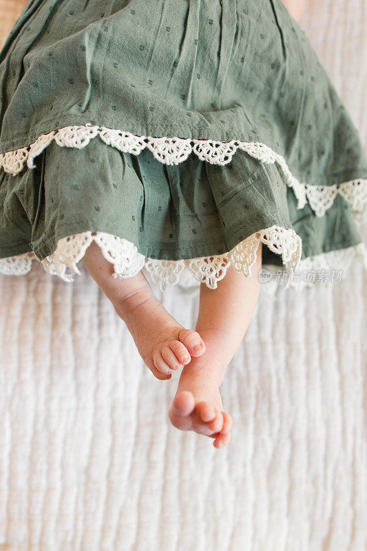 秋季新生女婴脚趾，脚和腿与舒适的奶油背景
