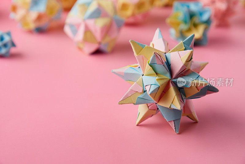 Set的multicolorÂ手工制作modularÂ折纸球或Kusudama孤立在粉红色的背景。视觉艺术，几何学，折纸艺术，纸工艺品。特写，选择性聚焦，复制空间。