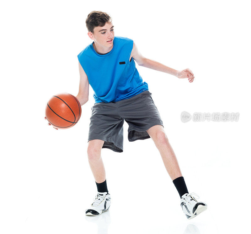 白种青年男篮球运动员在白种背景前手持篮球和用运动球