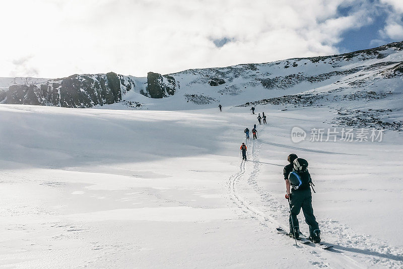 一群人在冰岛白雪覆盖的山上徒步旅行