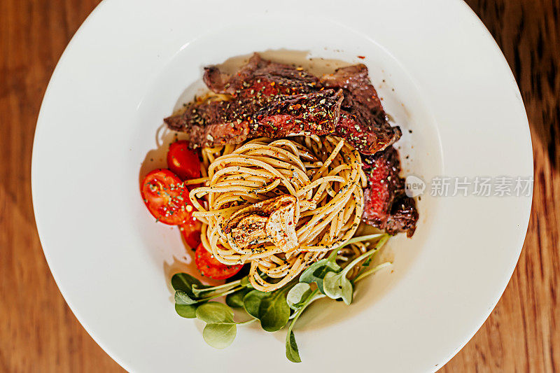 意大利面与牛肉，番茄，蔬菜精致的餐盘食物造型高分辨率股票照片