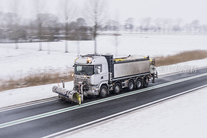 冬季服务卡车用扫雪机清理道路上的冰雪