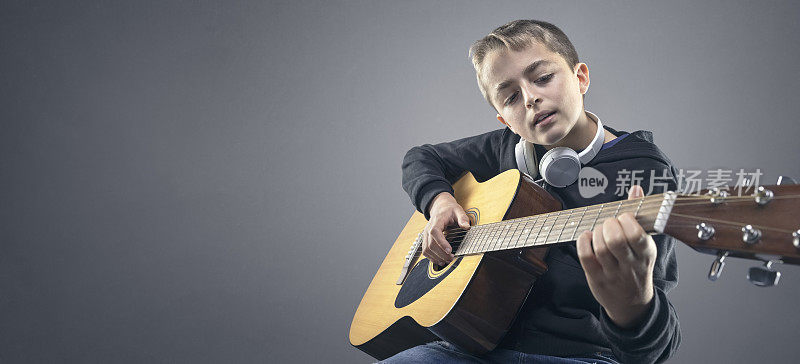 十几岁的男孩正在学习弹原声吉他