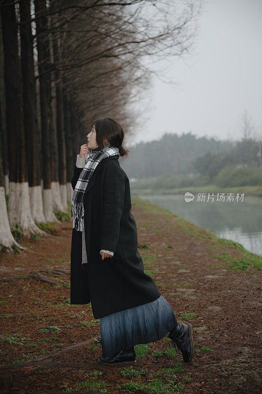 亚洲女孩走在河边的雨天