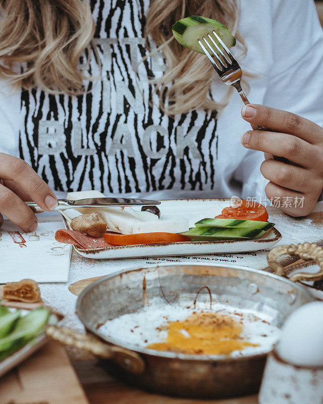 土耳其早餐，周日大早餐或早午餐与白奶酪和鸡蛋，土耳其早餐提供在餐厅，女人吃早餐，女人吃