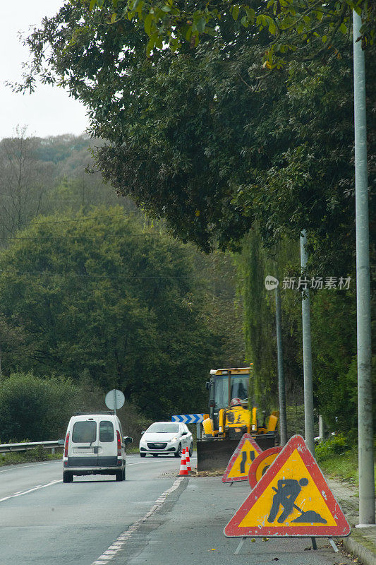 乡村道路前方工程标志、过往车辆、前方危险警告。