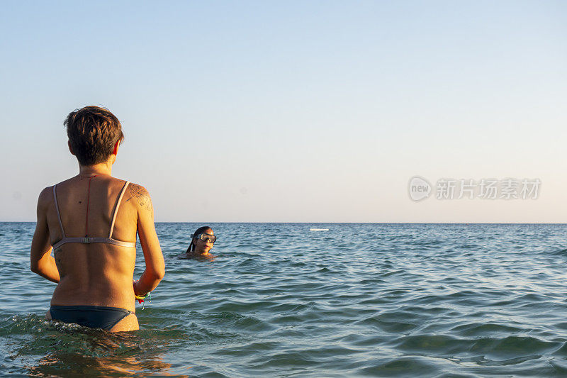 美丽的女人在海里游泳