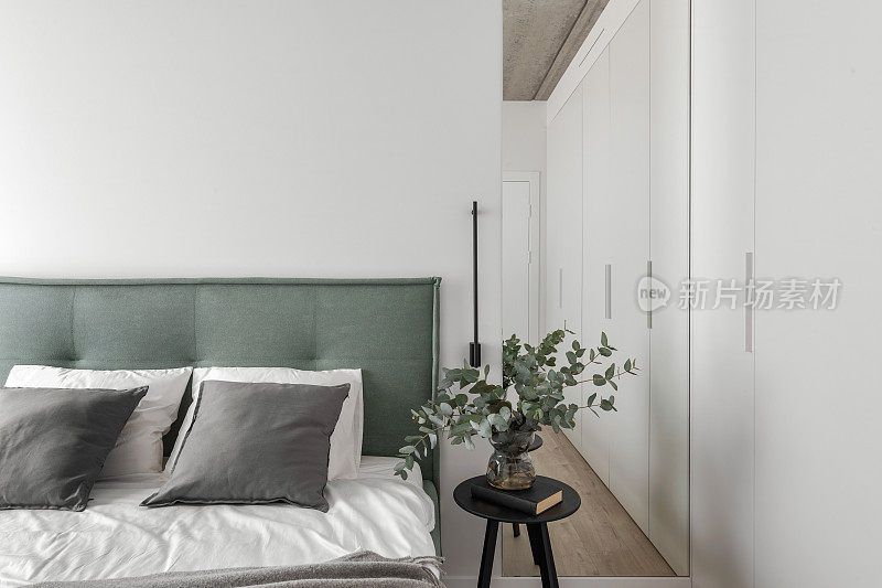 现代简约的卧室室内设计，浅绿色的床，桉树玻璃花瓶。北欧风格。唯美简约的室内设计理念。