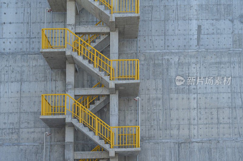 金属楼梯，混凝土墙上的黄色栏杆