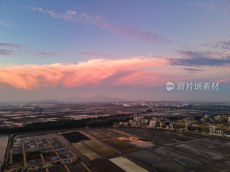 日落时村庄附近盐场的鸟瞰图