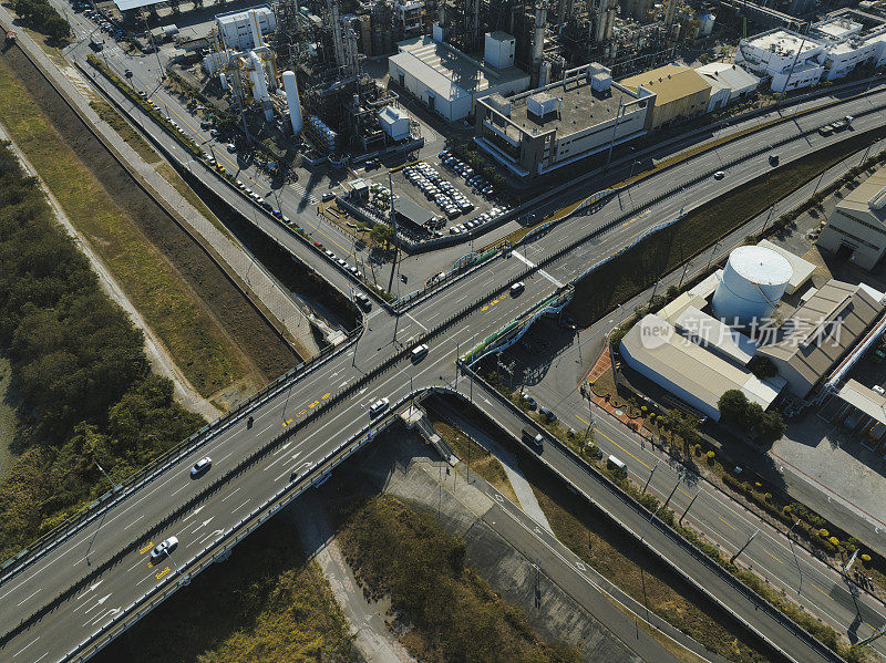 汽车在高速公路路口行驶的鸟瞰图。桥梁道路与绿色花园和树木相连接的建筑概念。