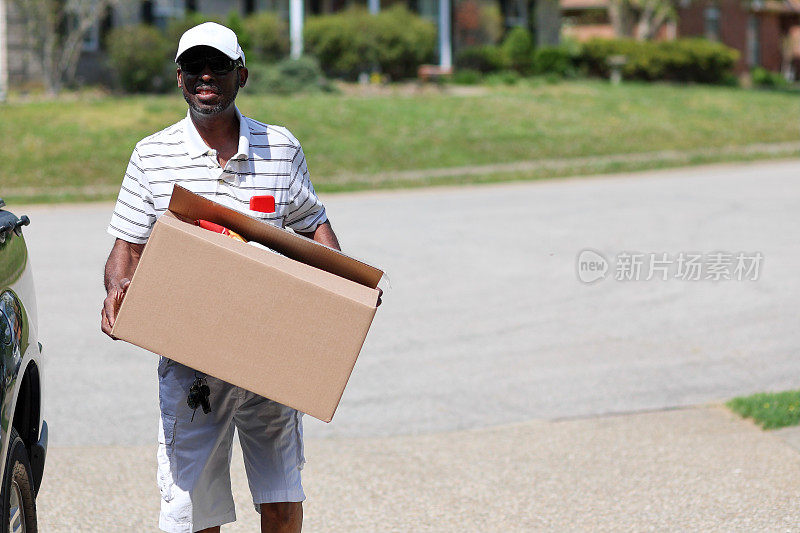 一个快乐的黑人男子拿着一盒捐赠的食物的肖像