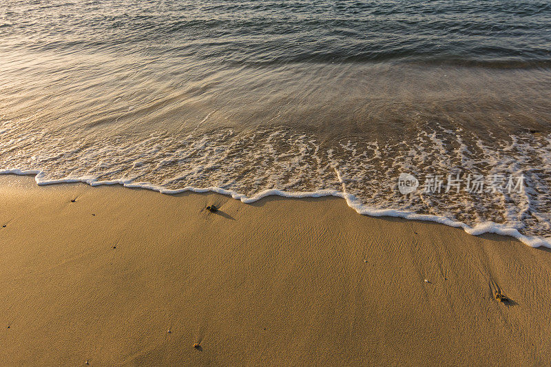 白色的浪花拍打着沙滩上的细沙