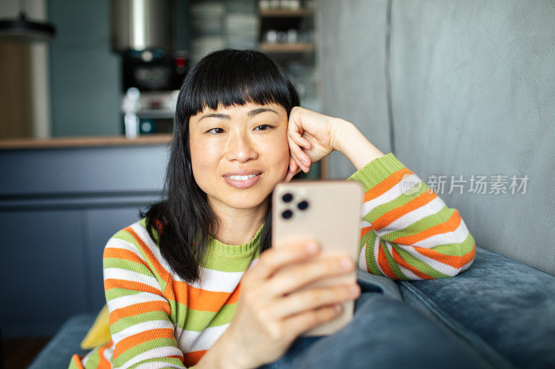 年轻的日本女性在家里使用智能手机