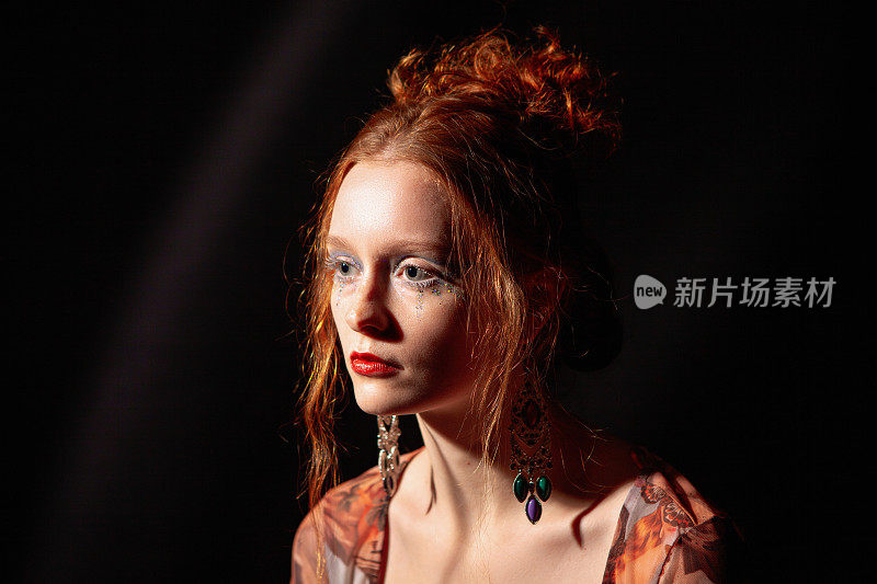 一个年轻漂亮的红发女人的艺术肖像，她的妆容很有艺术感