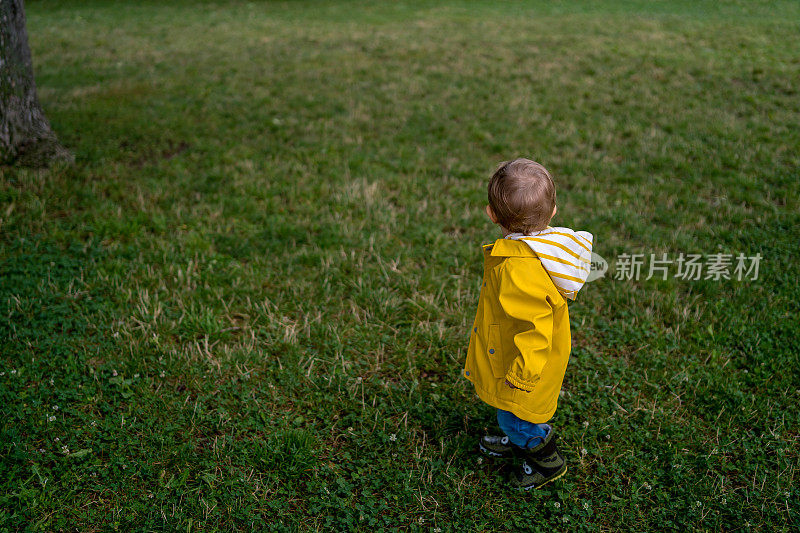 可爱的小男孩在下雨天玩耍