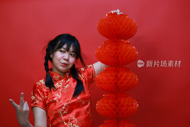 一个欢呼的女孩拿着一个红色的中国灯笼在工作室中国新年节日的概念