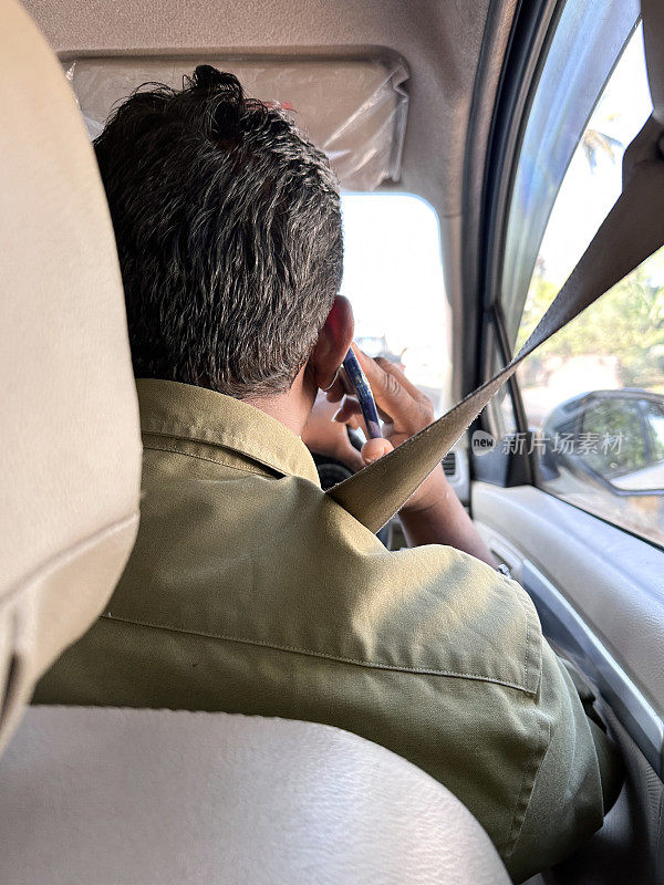 难以辨认的男性出租车司机系着安全带在高速公路上驾驶的形象，在私人出租车上听着电话，司机使用手机，危险驾驶的概念