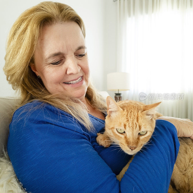 女人和他的姜黄色猫在家里。