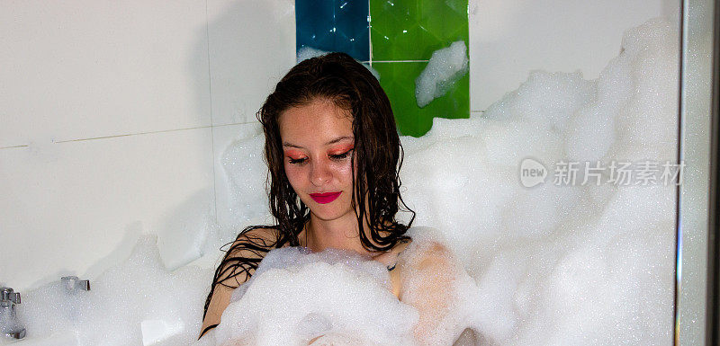 泡在泡沫浴缸里的年轻女子