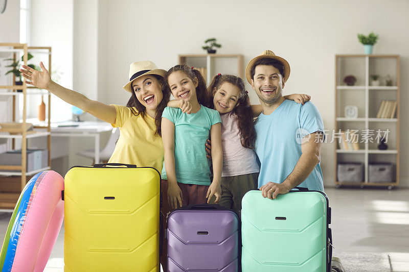 这是一幅笑容满面的父母和孩子们为暑假准备好行李的照片