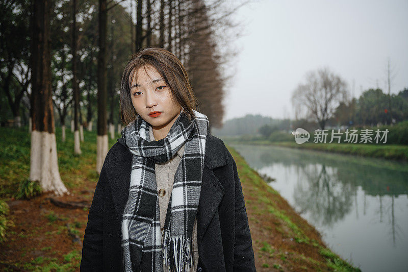 亚洲女孩走在河边的雨天