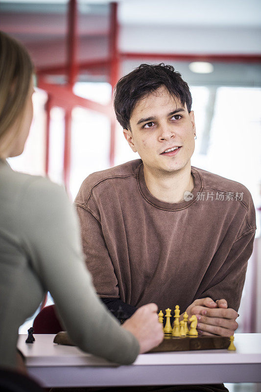 一对年轻夫妇，一个青年男子和一个青年女子在一起读一本书，兴致勃勃。