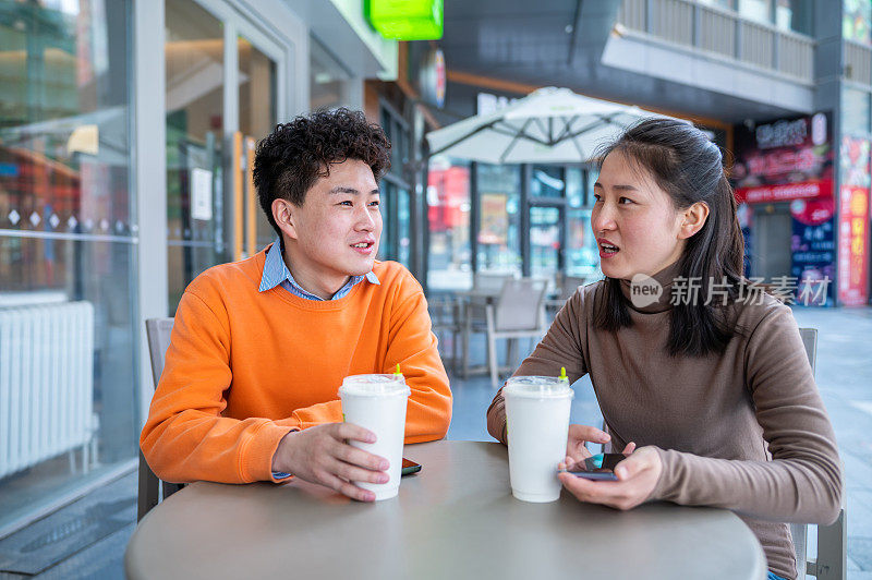 年轻的亚洲异性恋情侣在咖啡店约会