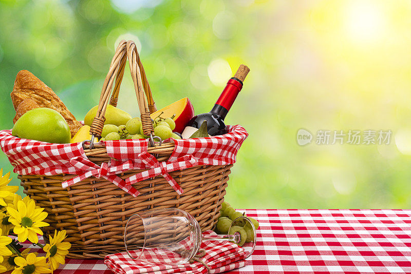 野餐篮子上的毯子，食物和酒在户外