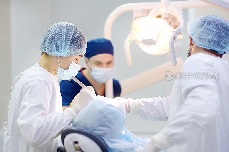 牙科手术中的外科医生和护士。在手术室麻醉病人。在诊所内安装植牙装置。