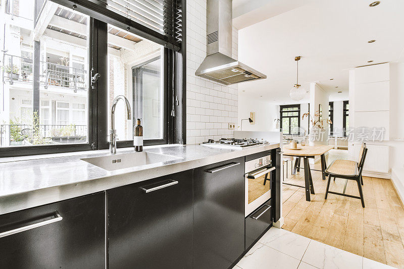现代厨房，白色家具和镶木地板在一个舒适的房子