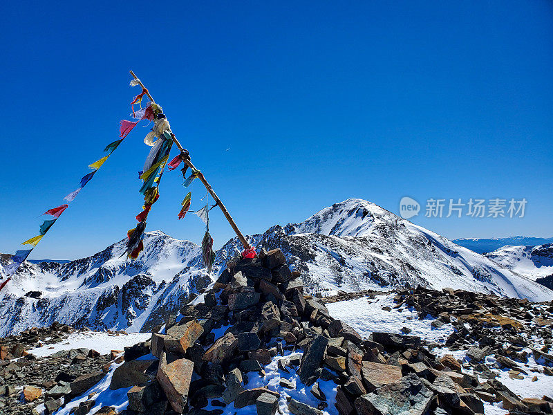 在冬季陶斯滑雪场的最高点克奇纳峰，经幡在山顶飘扬。惠勒峰在远处。