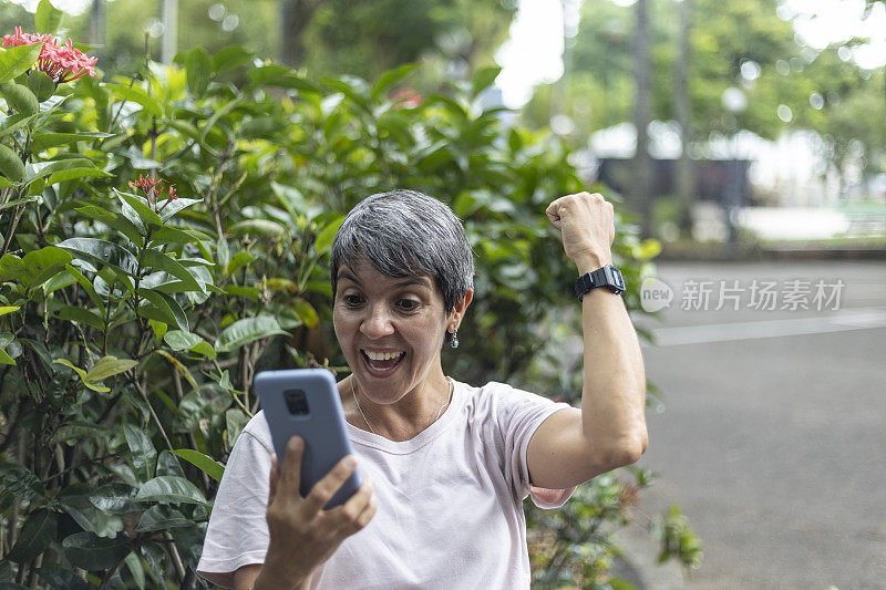 一名女子在公园里愉快地用手机交流