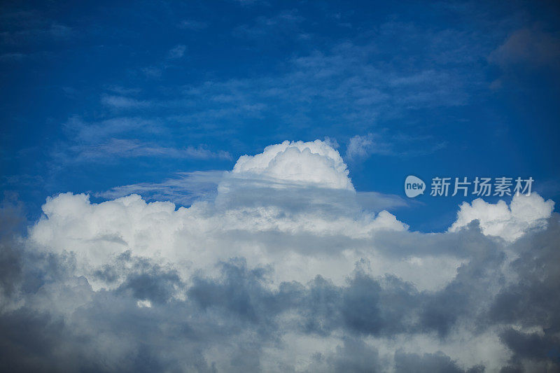蓝色天空中的戏剧性云景。多层云从远处看是由黑色和白色的云组成的。