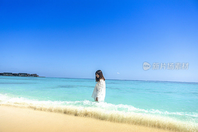 美女在艳阳高照蓝天海滩上的马尔代夫
