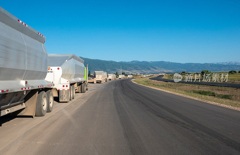 正在建设的高速公路上排着长长的卡车队。Kaysville,犹他州。