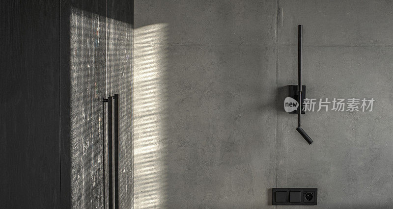 简约的黑色壁灯在现代室内灰色和黑色，混凝土墙设计，粘土墙。当代室内设计美学与具体细节