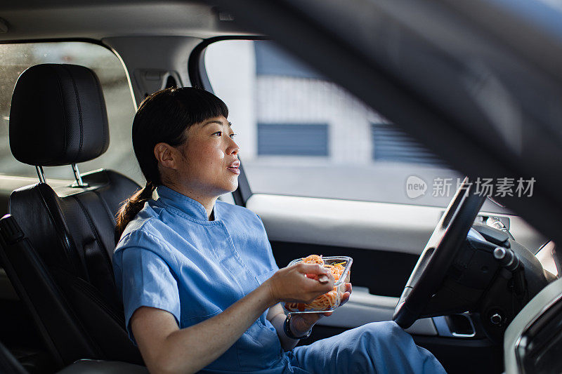 年轻的日本医护人员在车里吃午饭