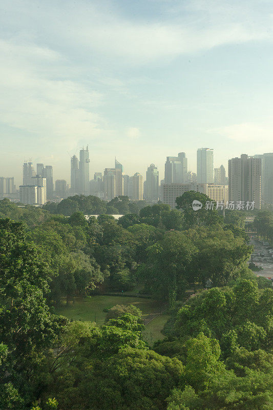 摩天大楼商业区的建筑景观在朦胧的清晨时分与巨大的花园地区印度尼西亚雅加达