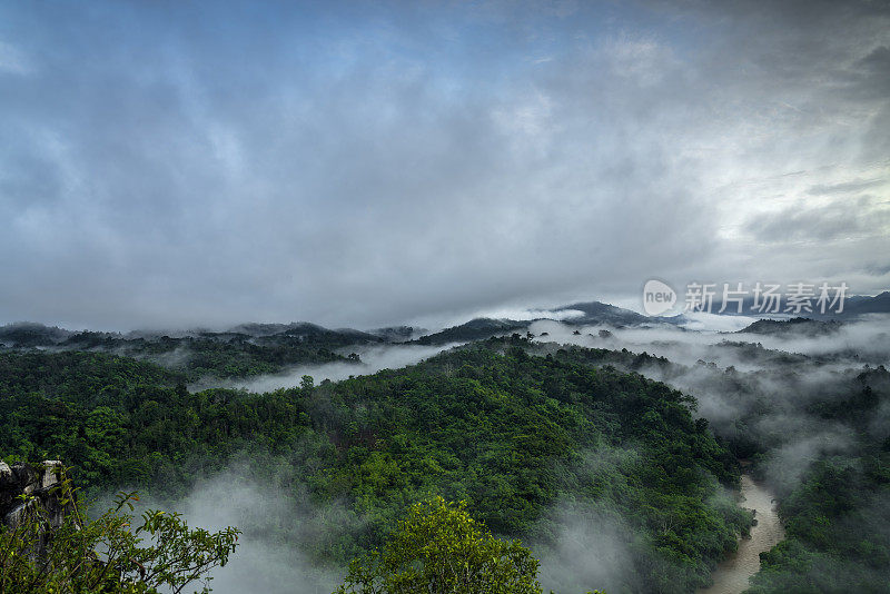 雾蒙蒙的丛林雨林与雾和分层的山脉范围从上面的日出。鸟瞰图。