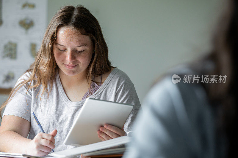 两个大学同学，都是年轻女性，在里面完全沉浸在她们的研究中，正在讨论她们的作业