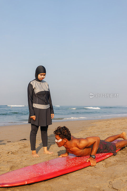 印尼男冲浪教练教穆斯林女子用冲浪板冲浪