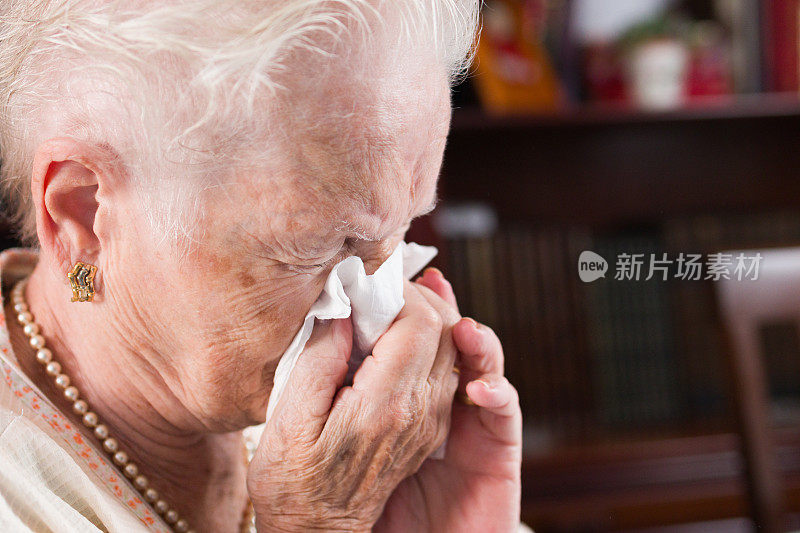 老年妇女因过敏而打喷嚏的特写