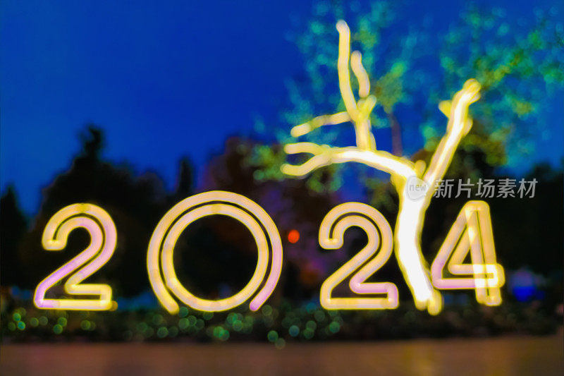 黄色新年街头花环的模糊照片，上面写着来年的数字，2024即将到来的概念，新的开始