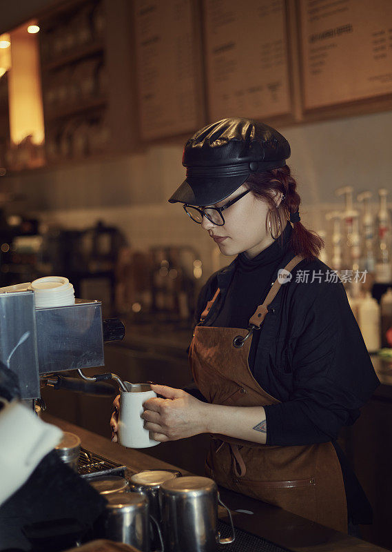 咖啡师在他工作的咖啡馆里为顾客准备咖啡。