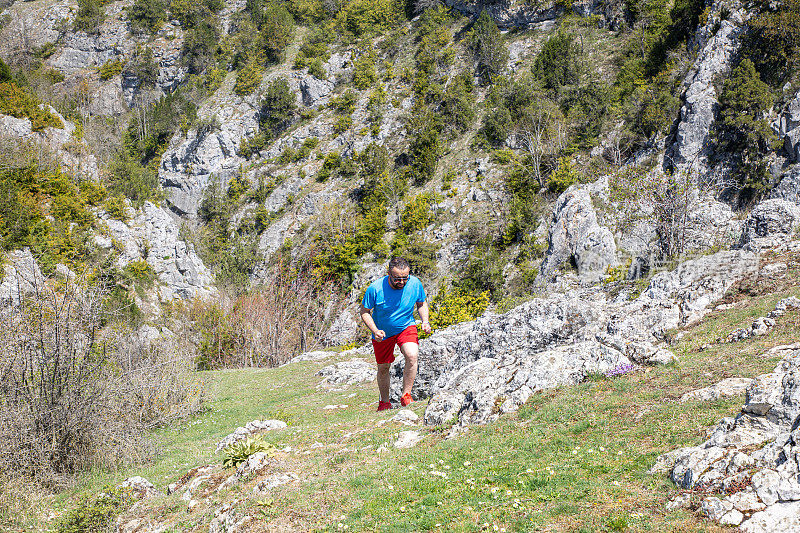 男越野跑者爬上山脊，高过山谷