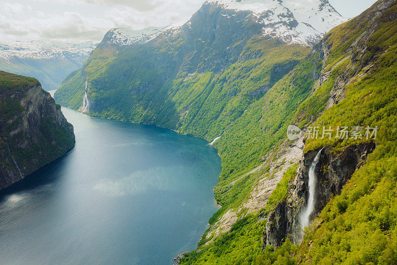 鸟瞰风景秀丽的瀑布落入水晶蓝色的海在挪威